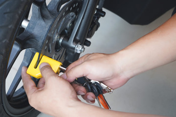 Motorcycle owner use a disc brake lock on a motorbike .Motorcycle Security and Anti-Theft Systems