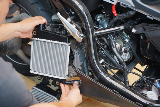 Expert technician install a radiator to motorcycle or scooter,The radiator is the main component of the cooling system and to keep the engine from overheating