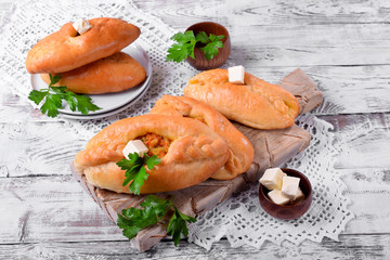 Rasstegai pie of yeast dough with meat filling on white wooden table. Traditional meal of Russian cuisine © kcuxen