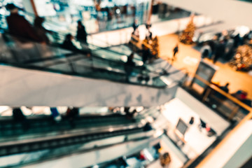 Abstract blurred background of the shopping center. Unfocused escalators with people
