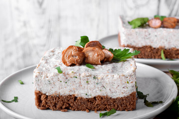 Salty mini cheesecake with roasted mushrooms and parsley on a ceramic plate