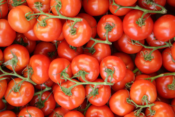 Pile of tomatoes for sale at supermarket. Background image on the subject of organic, vegan or...