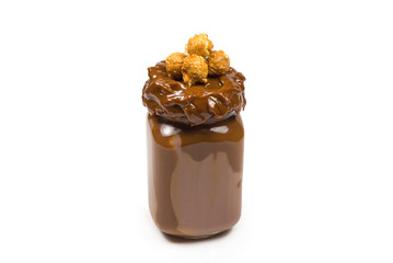 Chocolate milkshake with whipped cream, cookies, waffles, served in glass mason jar. 