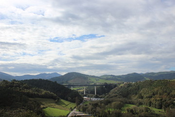 Fototapeta premium Green landscape with bridge and cloudy sky