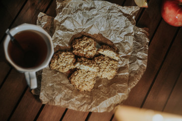 Oatmeal cookies on parchment paper on a background of apple and candles