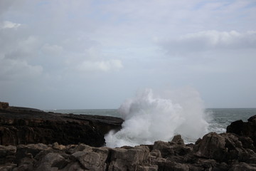 Fototapeta na wymiar Rough big waves clashing against the cliffs