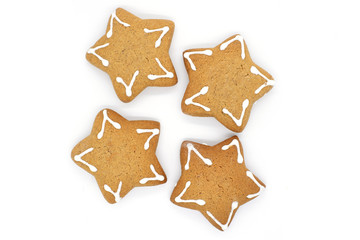 four star-shaped gingerbread cookies on a white background