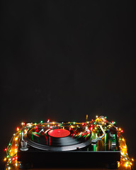 festive turntable with christmas ligts, dark copy-space background