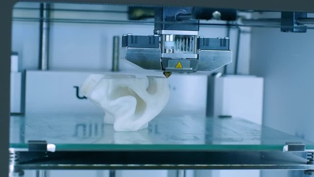 Modern 3D printer printing figure close-up macro.Automatic three dimensional 3d printer performs plastic white color modeling in laboratory. 3d-printing processing with white background