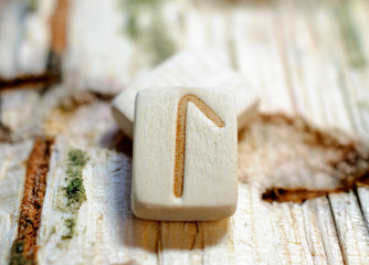 Wooden rune Laguz close-up on a wooden background. Soft focus