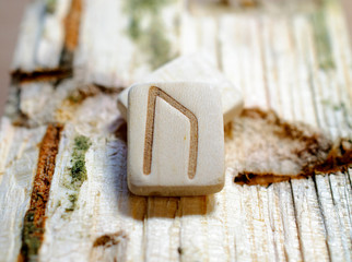 Wooden rune Uruz close-up on a wooden background. Soft focus