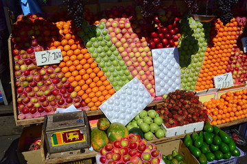 Street market stall with colorful fruits. Wooden box with small Sri Lankan flag. Small business for selling healthy food. Kandy, Sri Lanka