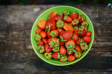 Bright juicy fragrant ripe strawberries in a green plate.