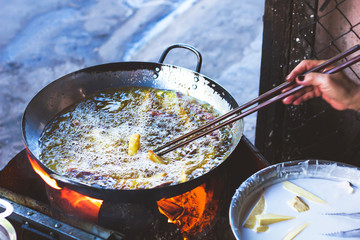 Travel Asia in Vietnam. Vietnamese fast food, Asian street food, batter-fried bananas in oil. Harmful,Traditional Harmful, Fatty Foods
