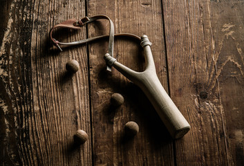 wooden sling shot on wood background © neosiam