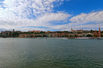 Obraz premium Panoramic view of picturesque Danube River and Buda side with Fisher Bastion and Buda Castle (Royal Palace) against colorful vibrant sky. Autumn in Budapest, Hungary