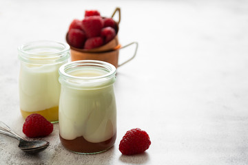 Fresh yogurt in glass jar with fruits. Healthy food, milk diary.