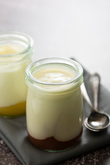 Fresh yogurt in glass jar with fruit jam. Healthy food, milk diary.