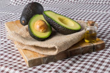 Avocados cut in halves with a checkered tablecloth. wooden surface. Healthy food.