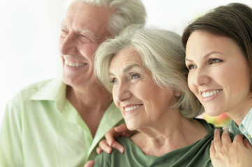 Close up portrait of happy senior parents with daughter at home