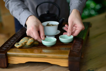 Fototapeta na wymiar Professional hands of a tea master are cooking show a tea ceremony. Tea ceremony set. White Chinese tea.
