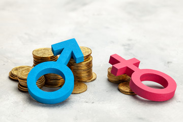 Discrimination of women. A large stack of coins and a gender symbol of a man and a small stack of...