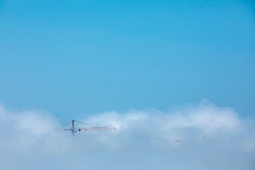 Fototapeta na wymiar Tower crane in the clouds