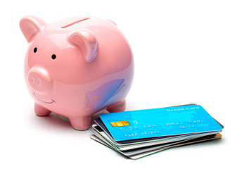 Pink piggy bank and credit cards in a stack isolated on white background. How to save money on a...