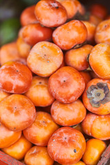fresh persimmons on a shelf in a store.