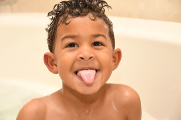 Toddler sticks his tongue out at bathtime