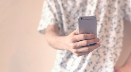 Fototapeta premium casual hipster standing next to the wall using smartphone. social issues , social personal problem