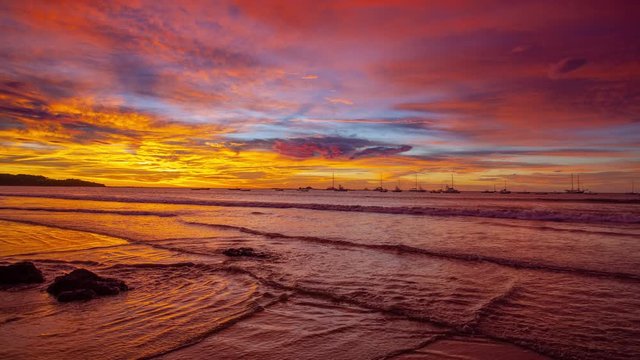 colorful sunset seascape with camera pan across the beach, Filmed in 4K RAW