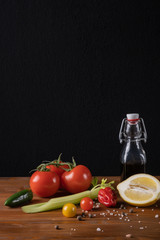 Fresh organic tomato juice decorated with raw tomatoes, leaves on a dark rustic wooden background. Healthy diet nutrition concept. 