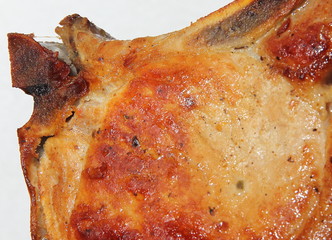 Baked piece of pork meat on aluminum foil, the process of cooking meat dishes in the oven.