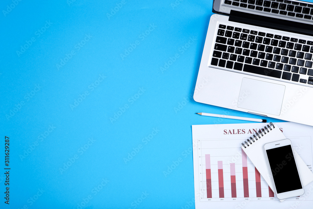 Aufkleber laptop computer with paper charts, notepad and smartphone on blue background