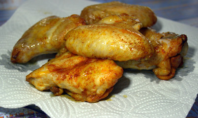  Juicy appetizing grilled chicken wings lie on a napkin. Close-up.