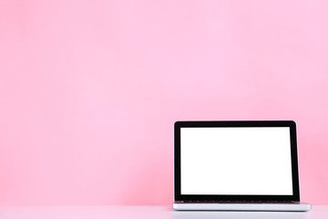 Laptop computer on pink background