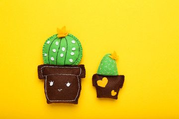 Different soft toy of cactuses on yellow background