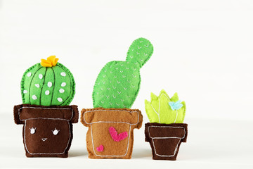 Different soft toy of cactuses on white background