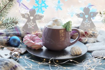 Cup with a drink, sweet dessert, Christmas decor, illumination on a wooden surface on a background of a window, winter holidays