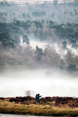 Hiker walking in misty landscape, Derbyshire