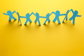 Paper chain people on yellow background