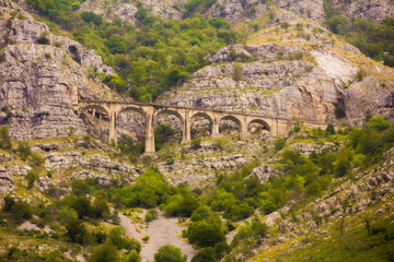 Fototapeta premium The view of old high mountain breathtaking railway viaduct or mountain bridge of old railway in MONTENEGRO, Europe
