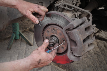 Mechanic fix cotter pin safety wire  of nut lock of bearing on disc brakes