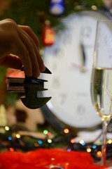  In the child’s hand is a small New Year’s bat toy against the background of New Year’s clock and glasses with champagne. 2020 - Year of the Rat