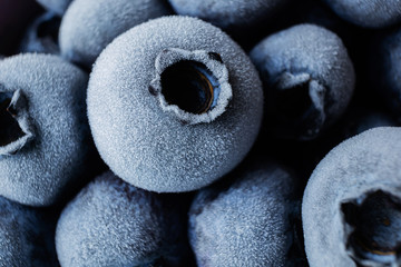 Frozen blueberries closeup. Macro photo, detail, texture. The concept of preserving berries, wholesome vitamin food. Muted tones.