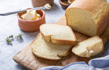 Fresh homemade crisp bread  and slices with olive oil, butter and green olives, top view.  Baking concept