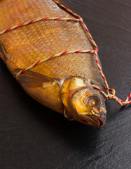 Smoked bream on a slate board. Bream on a black surface of slate close-up. Top view.
