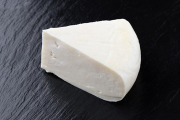 Cheese on a slate surface. Piece of cheese close-up.
