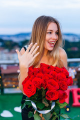 The girl smile and shows ring on the ring finger. woman holds a